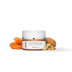 Eine Creme in einem Tiegel neben Karotten und Waln&uuml;ssen.